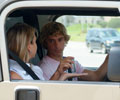 driver handing cellphone over to passenger