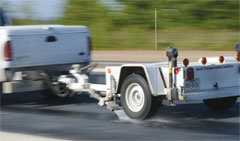 TTI's skid rig being pulled behind a pickup truck during testing.