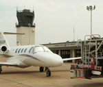 Corporate jet parked in front of air traffic control tower
