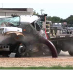 Large truck impacting a crash barrier during a crash test.