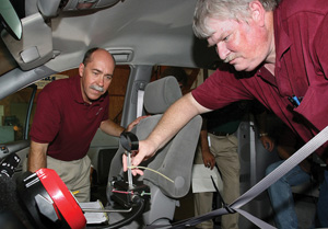 TTI researchers check the installation of assistive equipment inside a vehicle