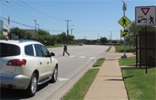 driver of a car waiting for pedestrian to walk across a crosswalk utilizing the rectangular rapid-flashing beacons