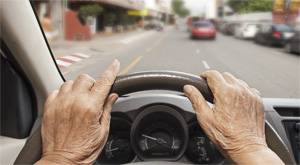 view of hands of an elderly person holding a steering wheel
