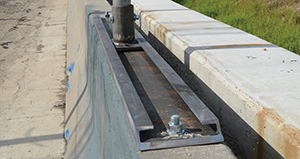 closeup of the sliding base with chute sign-post design mounted on a concrete barrier