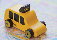 wooden toy taxi placed on a city map
