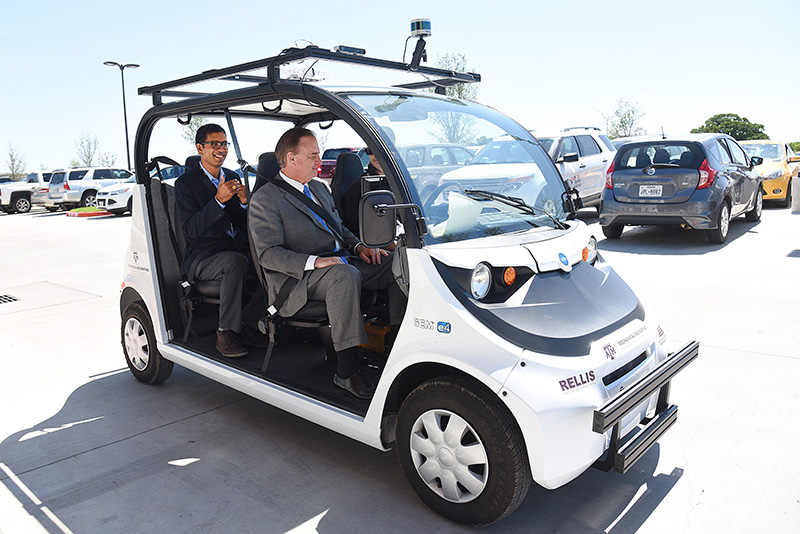 A photo of an autonomous golf cart with passengers.