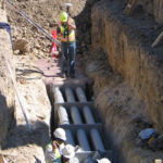 Construction workers digging near underground utilities.