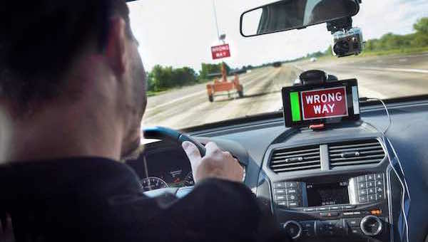 Test driver with 'wrong way' alert showing on a dashboard-mounted phone or tablet
