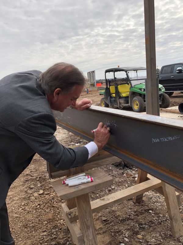 TAMU System Chancellor John Sharp signing the highest beam of the new TTI headquarters building at RELLIS.