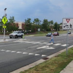 A pedestrian crossing a road using a crosswalk.