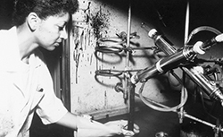 Historical photo of a woman doing aggregate testing in a laboratory.