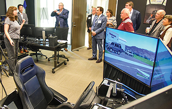 The TTI Advisory Council touring the driving simulator in the TTI Headquarters building.