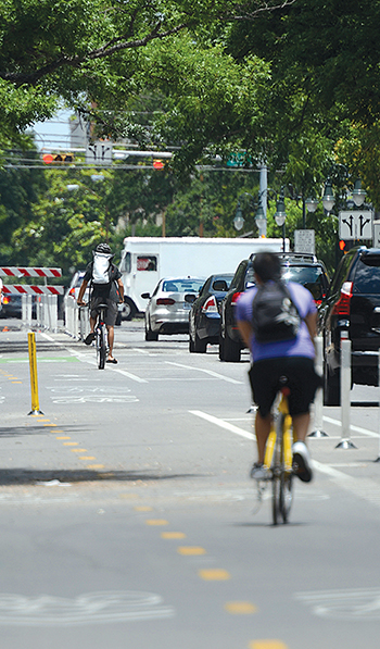 Bicyclists using a dedicated bike lane next to a busy roadway.