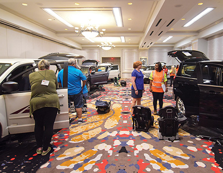 Room holding several full-size vehicles and car seats used during the Seat Check training offered during the 2019 Texas Child Passenger Safety Conference.