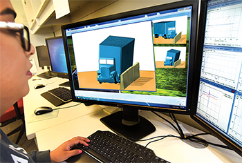 Researcher working with computer simulation software to simulate an 18-wheeler crash into a newly designed concrete barrier.