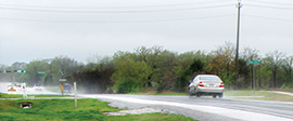 Cars driving down a wet road.