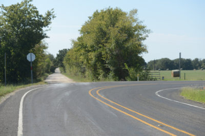 A two-lane, rural roadway with a sharp curve.