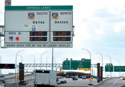LBJ Express toll lanes (I-35E corridor) in Dallas, Texas showing overhead signage displaying dynamic toll rates for 35E South and 35E North.