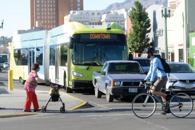 El Paso, Texas public transit bus waiting at an intersection where bicyclist and pedestrian are crossing.