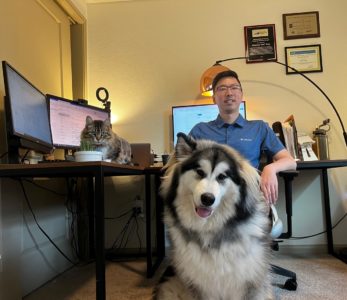 Photo of Jack Kong and his pets in his home office.