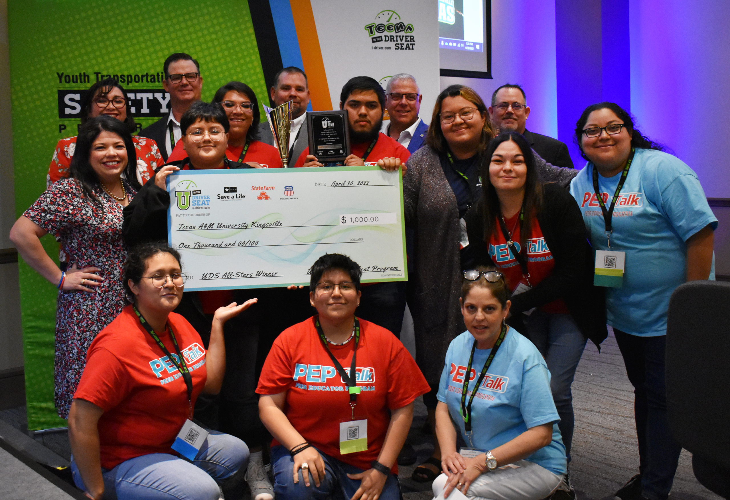Group from Texas A&M University — Kingsville holding an All-Star winner check in front of a Youth Transportation Safety Program sign.