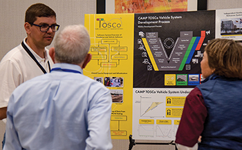 Researcher presenting information about the Optimization for Signalized Corridors (TOSCo) project as part of a poster session.