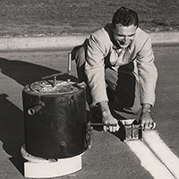 Historical photo of a man hand striping pavement.