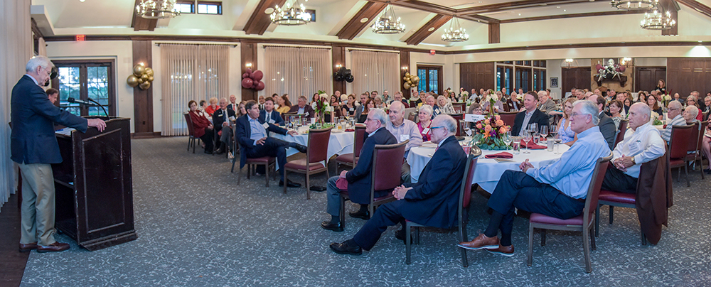 Photo taken during the award presentation with a wide view of the guests in attendance and David Laney speaking at the podium.