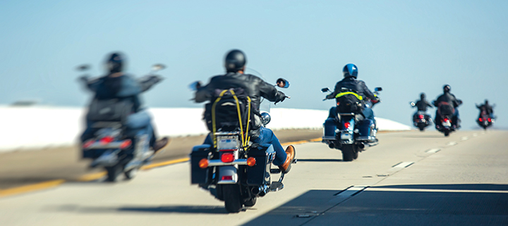 Photograph of 6 motorcyclists traveling along a two-lane highway.