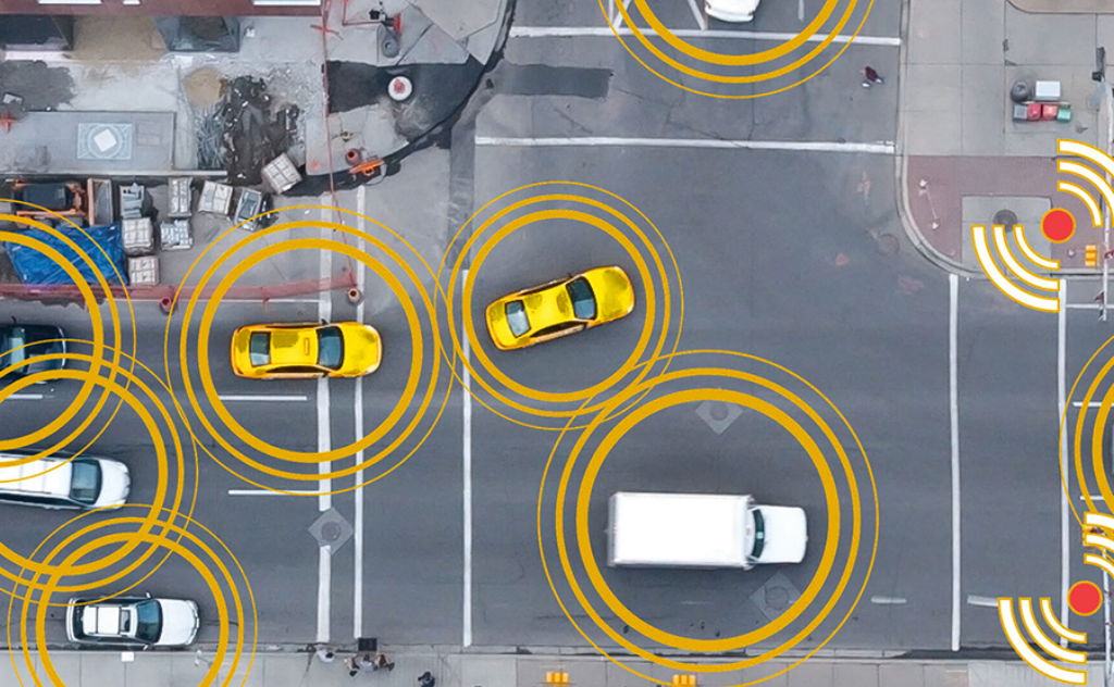 Aerial view of vehicles at an intersection with yellow circular signal graphics, illustrating connected or smart vehicle technology.
