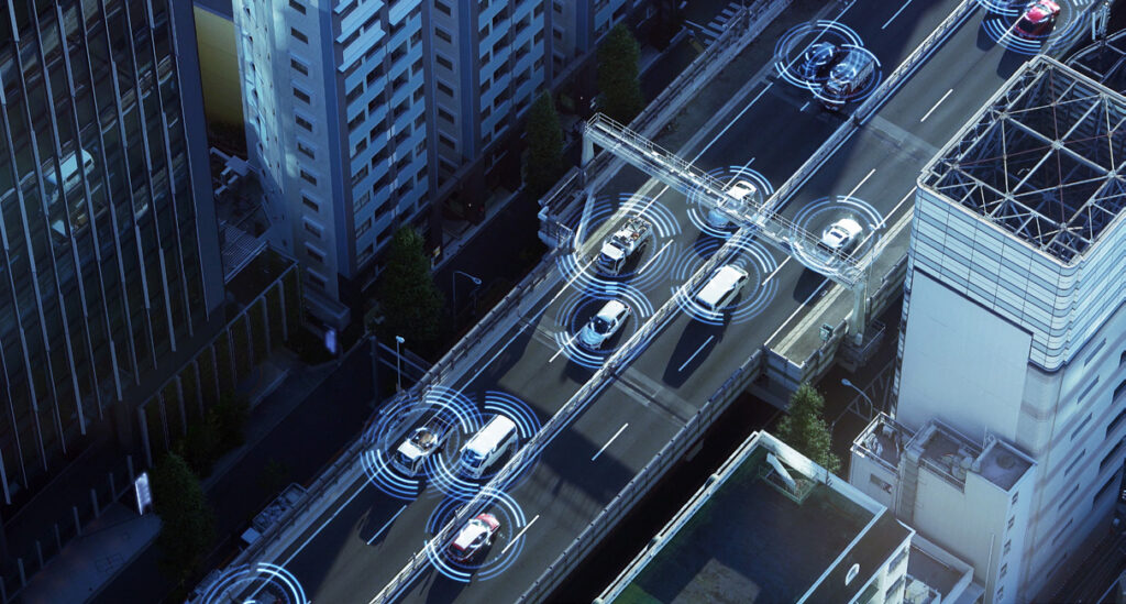 Aerial view of cars driving on a city highway with digital overlay graphics representing vehicle connectivity and communication technology.