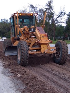 grader in dirt on highway under construction