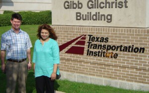 two individuals by sign: Gibb Gilchrist Buidling Texas Transportation Institute