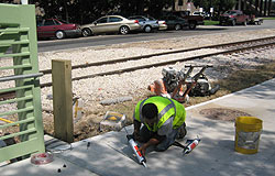 Worker applying caulk to a bike traffic counter device