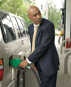 man in suit pumping gas