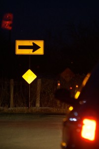 An arrow sign reflected at night