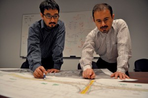 two researchers looking at a blueprint