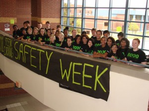 Teenagers at Creekview High School behind a banner promoting National Teen Driving Safety Week.