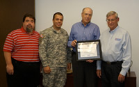 Dennis Christiansen (right center) holds a plaque he received from the Employer Support of the Guard and Reserve. Also honored was Lee Gustavus (far left). Also pictured are Chip Sosa (left center) and George Dresser (far right).