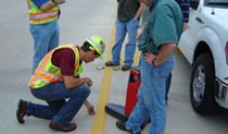 committee members take measurements of pavement markings