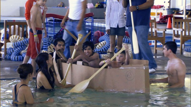 Students paddling a canoe made out of cardboard