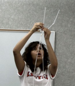 Student building a straw tower.