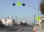 A pedestrian crossing in Los Angeles, California with overhead yellow flashing beacons.