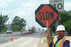 work zone worker with SLOW sign