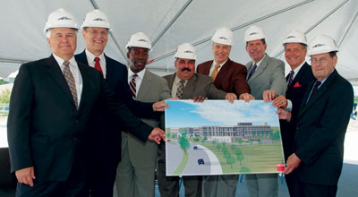 group of officials holding an artist rendition of the TTI State Headquarters