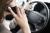 person talking on cell phone while driving