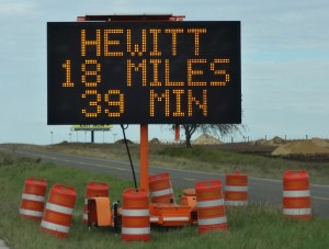 Portable travel time display sign showing: Hewitt, 18 miles, 39 min.