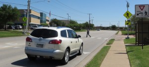 Vehicle approaching a pedestrian walking across a roadway.
