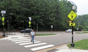 pedestrian using crosswalk equipped with a rectangular rapid-flashing beacon
