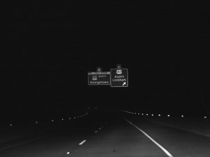 Overhead highway sign at night.